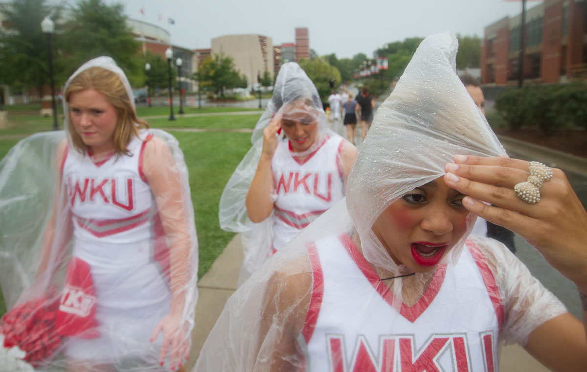 Looking to escape from the rain, Louisville senior Jasmine Taylor walks down Avenue of Champions to a tent on South Lawn at Western Kentucky University Sept 1, 2012. The rain before WKU's first football game of the season caused Topper Walk, a pre-game tradition in which players, cheerleaders and marching band members walk to the stadium, to be cancelled.
