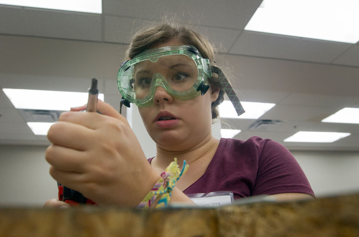 VAMPY camper Olivia Gilliam of Madisonville inspects her screwdriver before attaching two boards to be used for a Rube Goldberg machine in the STEAM Labs class July 3, 2015. The finished machine used a complicated series of tasks to complete a simple task.