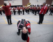 A backbend to touch a plume to the field before football games is a tradition for field commanders at Division 1 schools. Aleshia Akin, a senior from Magnolia, Ky., practices before a football game Oct. 17, 2009, while the Big Red Marching Band rehearses behind her outside Diddle Arena on the campus of Western Kentucky University.