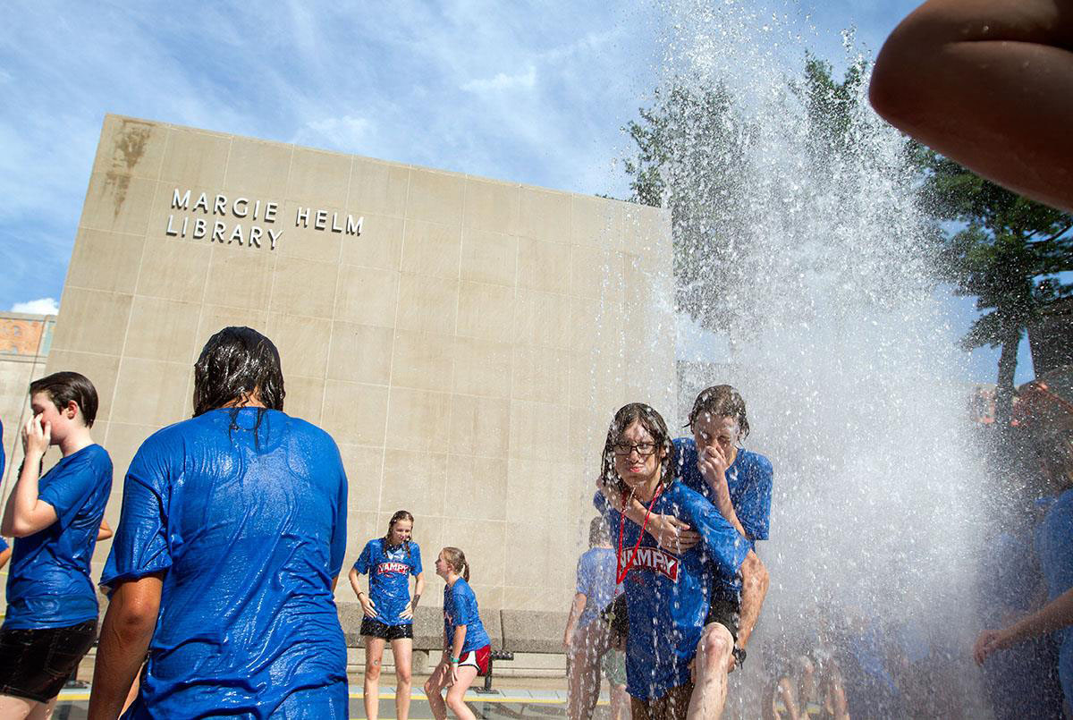 VAMPY campers run through the fountain outside Margie Helm Library July 15. Running through the fountain is a tradition after classes on the last day of VAMPY.