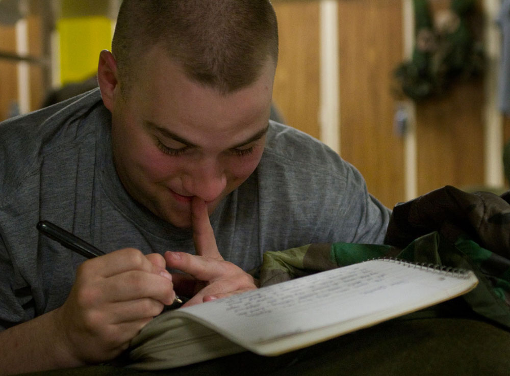 During nightly personal time, Dylan Alm writes a letter to his girlfriend July 19 in the company barracks.