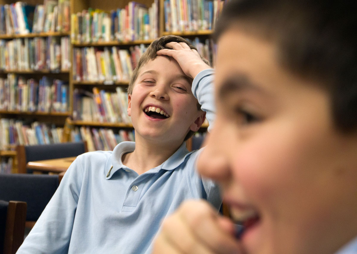 Fifth-grader Charles Laniak laughs at classmate Brenan Hain while setting up the game.