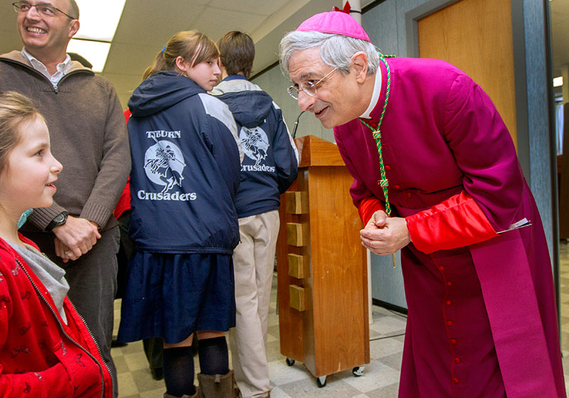 Six-year-old Clara Stoldoka of Albany talks with Bishop Matano after attending Mass at St. Mary Church Jan. 5. Bishop Matano visited with Mass-goers for more than an hour after celebrating his first public Mass as Bishop of Rochester.