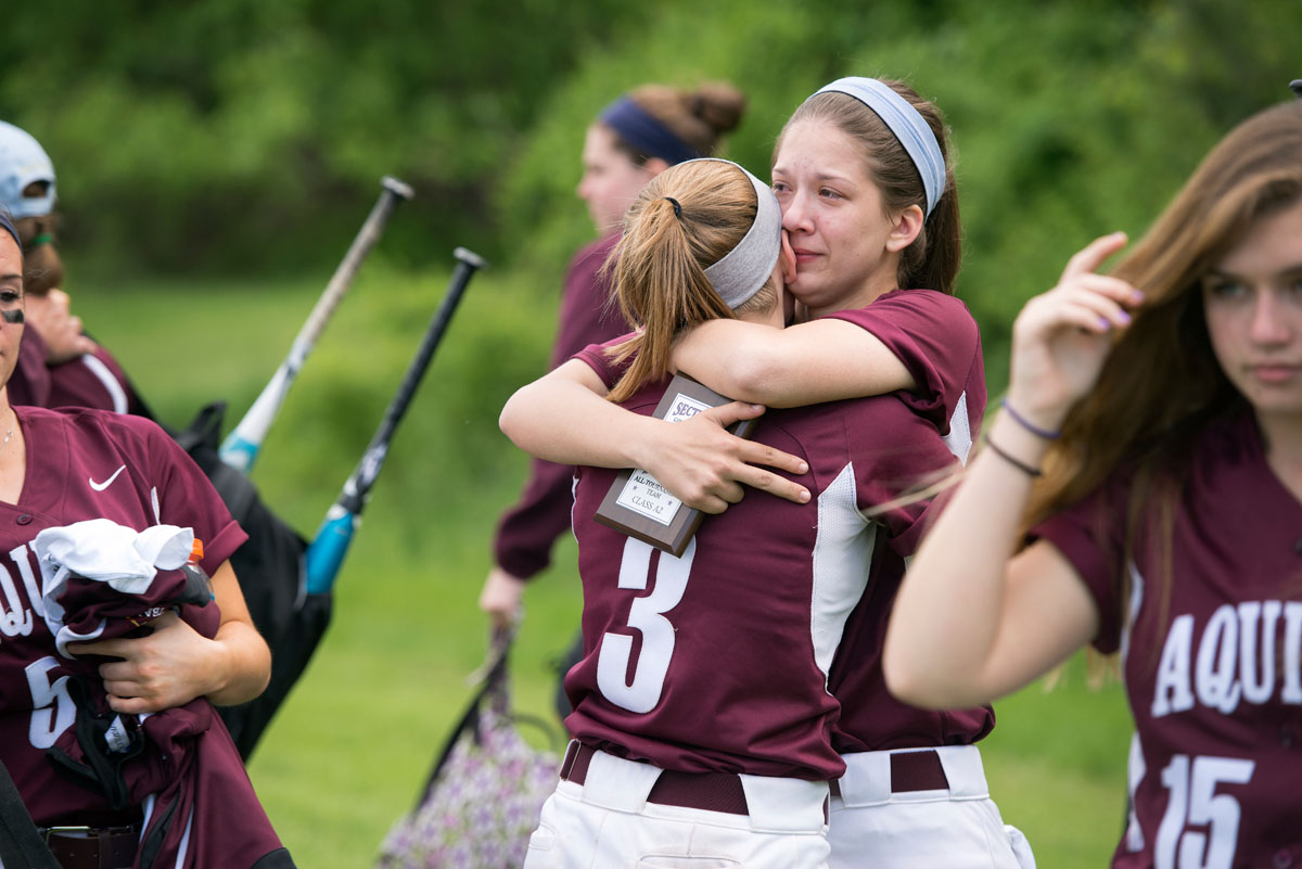 Sam Ashman hugs Sarah Gensler (3) after Aquinas' 5-3 loss in the Section Five Class A2 championship game. Ashman was named to the all-tournament team.