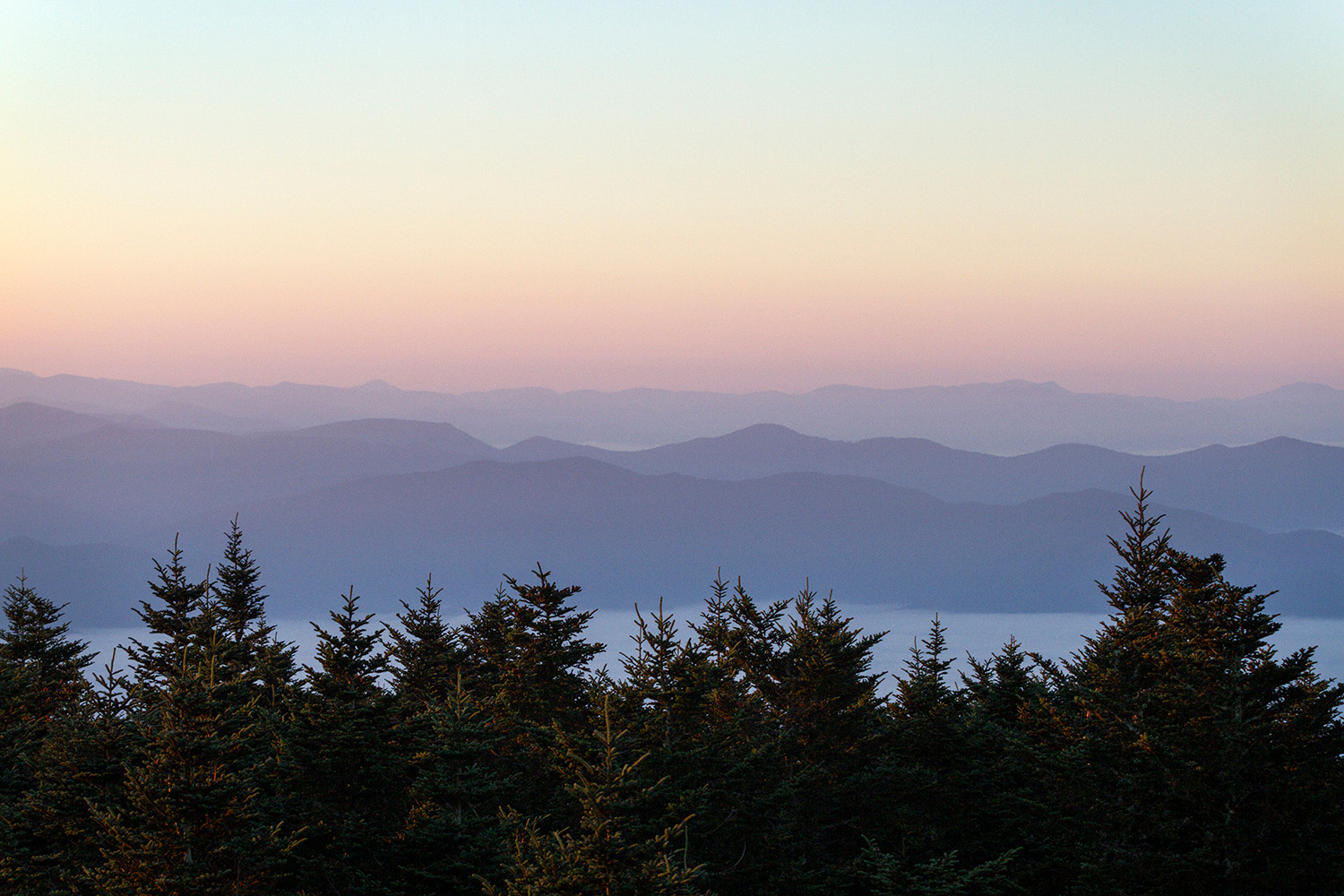Pastel colors fill the western sky at sunrise as seen from Kuwohi inside Great Smoky Mountains National Park in Tennessee on Oct. 10, 2023.